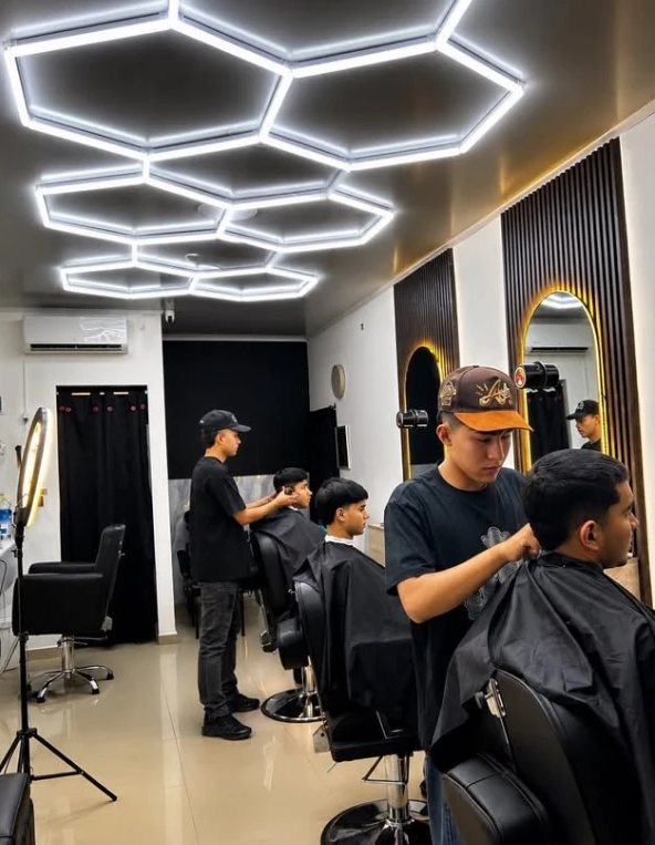 Barberos trabajando bajo las luces hexagonales